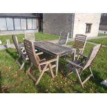 A slatted teak garden table and six folding elbow chairs bearing "Swan Hattersley Garden Furniture"