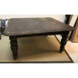 A late 19th Century oak dining table, the top with carved frieze,
