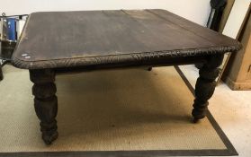 A late 19th Century oak dining table, the top with carved frieze,