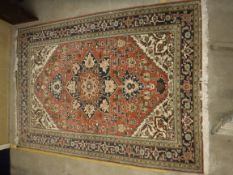 A Persian carpet, the central panel set with stylised flower head motif on a pink and cream ground,