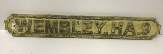 A modern wooden sign inscribed "Wembley HA9",