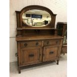 A circa 1900 oak sideboard with mirrored back over two drawers and two cupboard doors on square