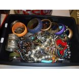 A box and carrier bag of assorted costume jewellery to include bangles and beaded necklaces