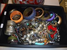 A box and carrier bag of assorted costume jewellery to include bangles and beaded necklaces