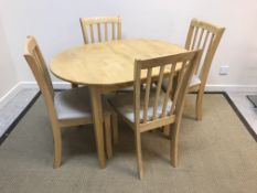 A modern beech extending dining table with integral leaf,