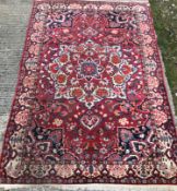 A Caucasian carpet, the central panel set with a flower head medallion on a red ground,