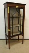 An Edwardian mahogany and satinwood strung display cabinet with single glazed door enclosing two