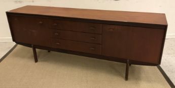 A 1960's teak sideboard with three central drawers flanked by two cupboard doors on elliptical