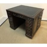 An Edwardian mahogany library desk, the plain top with leather insert above a kneehole,