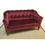 An early 20th Century two seat scroll arm settee, with red upholstery and cabriole legs,