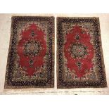 A pair of fine Oriental rugs, the central panels set with floral decorated circular medallion on a