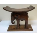 An African carved hardwood "elephant" stool on rectangular chamfered base, 53 cm wide x 49 cm high
