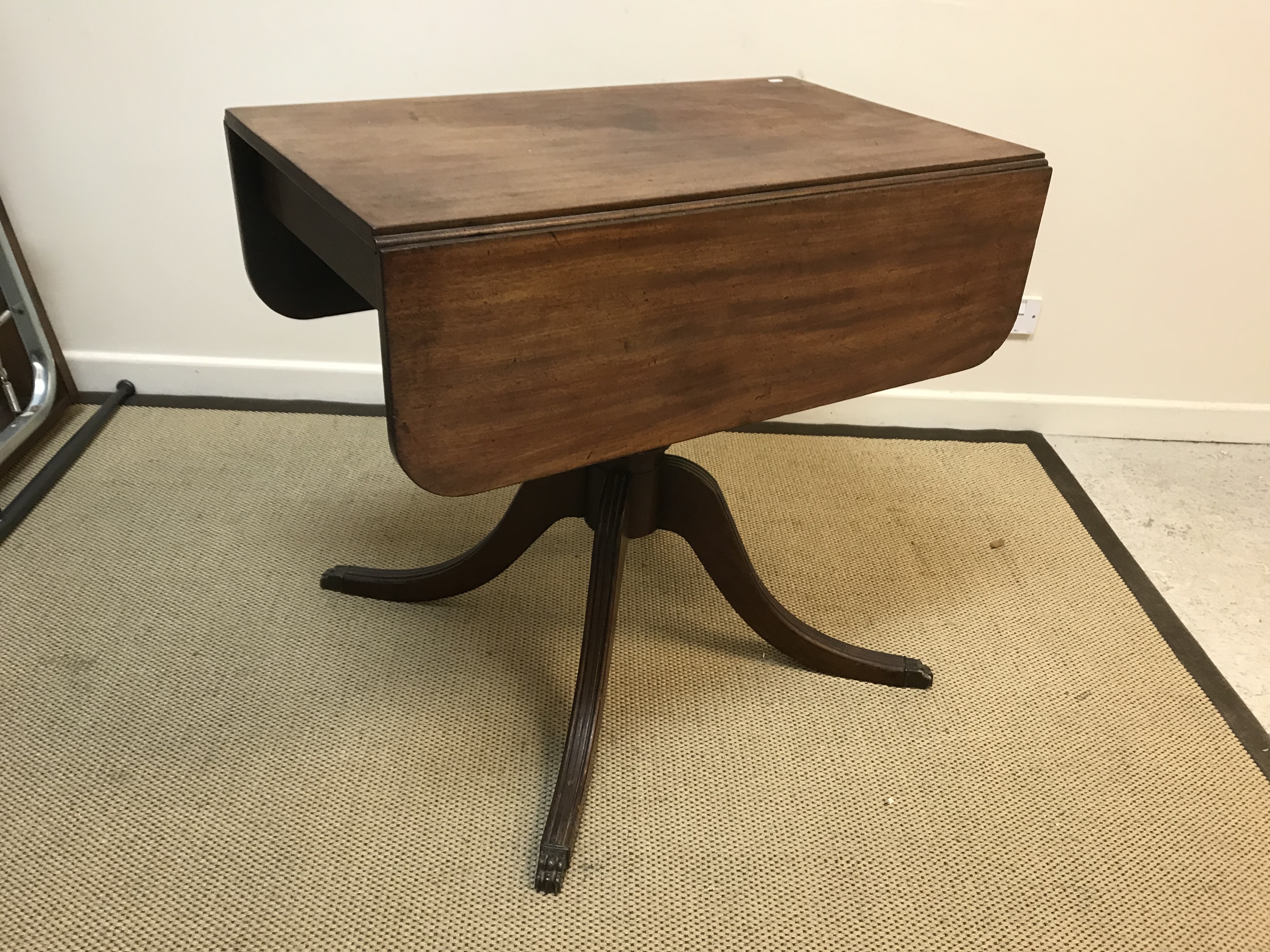 A 19th Century mahogany Pembroke table, the rounded rectangular drop-leaf top on a central turned