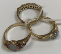 Three 9 carat gold dress rings, one set with opal, another with aquamarine and the other red and