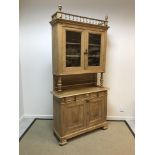 A Continental pear wood buffet with glazed upper section and two drawers over two cupboard doors