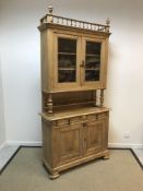 A Continental pear wood buffet with glazed upper section and two drawers over two cupboard doors