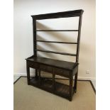 A 19th Century oak dresser, the three tier open plate rack with iron cup hooks over three drawers on