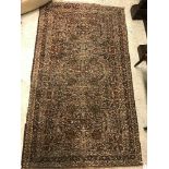 A Persian rug, the central panel set with all-over floral design in brown and cream, within a