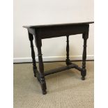 An 18th Century oak side table, the two plank top with moulded edge above a plain frieze on turned