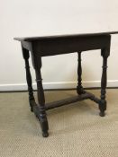 An 18th Century oak side table, the two plank top with moulded edge above a plain frieze on turned