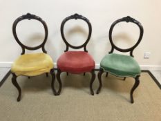 A set of three Victorian mahogany balloon back dining chairs with red, green and yellow velvet