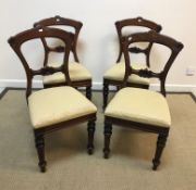 A set of four late Victorian dining chairs, raised on turned and ringed front legs with yellow
