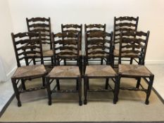 A set of eight North Country style beech and ash ladder back rush seat dining chairs on turned
