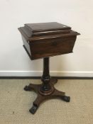 An early Victorian rosewood teapoy of caddy form, the top opening to reveal a four canister interior