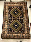 A Caucasian rug, the central panel set with two repeating medallions on a dark blue and pale blue