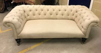 A Victorian buttoned upholstered scroll arm Chesterfield sofa on foliate carved and ebonised