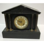 A late 19th Century French black slate cased mantel clock of architectural form with brass capped