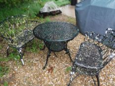 Two painted cast metal two seat garden benches, together with a painted cast metal circular table