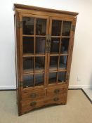 A 20th Century Chinese elm display cabinet with two glazed doors over two short and one long