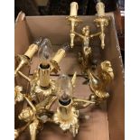 A set of four polished brass / gilded brass wall sconces as cherubs holding aloft twin lights in the