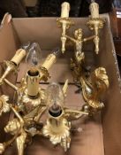 A set of four polished brass / gilded brass wall sconces as cherubs holding aloft twin lights in the