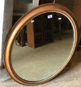 A 19th Century giltwood and gesso oval wall mirror with beaded decoration