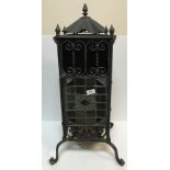 A late Victorian wrought iron and leaded glazed greenhouse type heater on cabriole legs to scroll