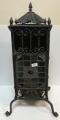 A late Victorian wrought iron and leaded glazed greenhouse type heater on cabriole legs to scroll