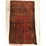 An Afghan prayer rug, the central panel set with stylised tree and pillar decoration on a red