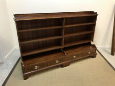 An Edwardian mahogany open bookcase by Goodall Lamb & Heighway Limited, the three quarter