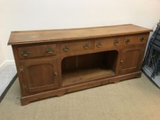 A modern oak dresser in the 19th Century manner, the plain top above four drawers, a central dog