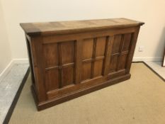 A 20th Century oak side unit in the 19th Century style, the plain top over three panels, quartered
