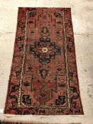 A Caucasian rug, the central panel set with stylised medallion on a pink geometric and stylised bird