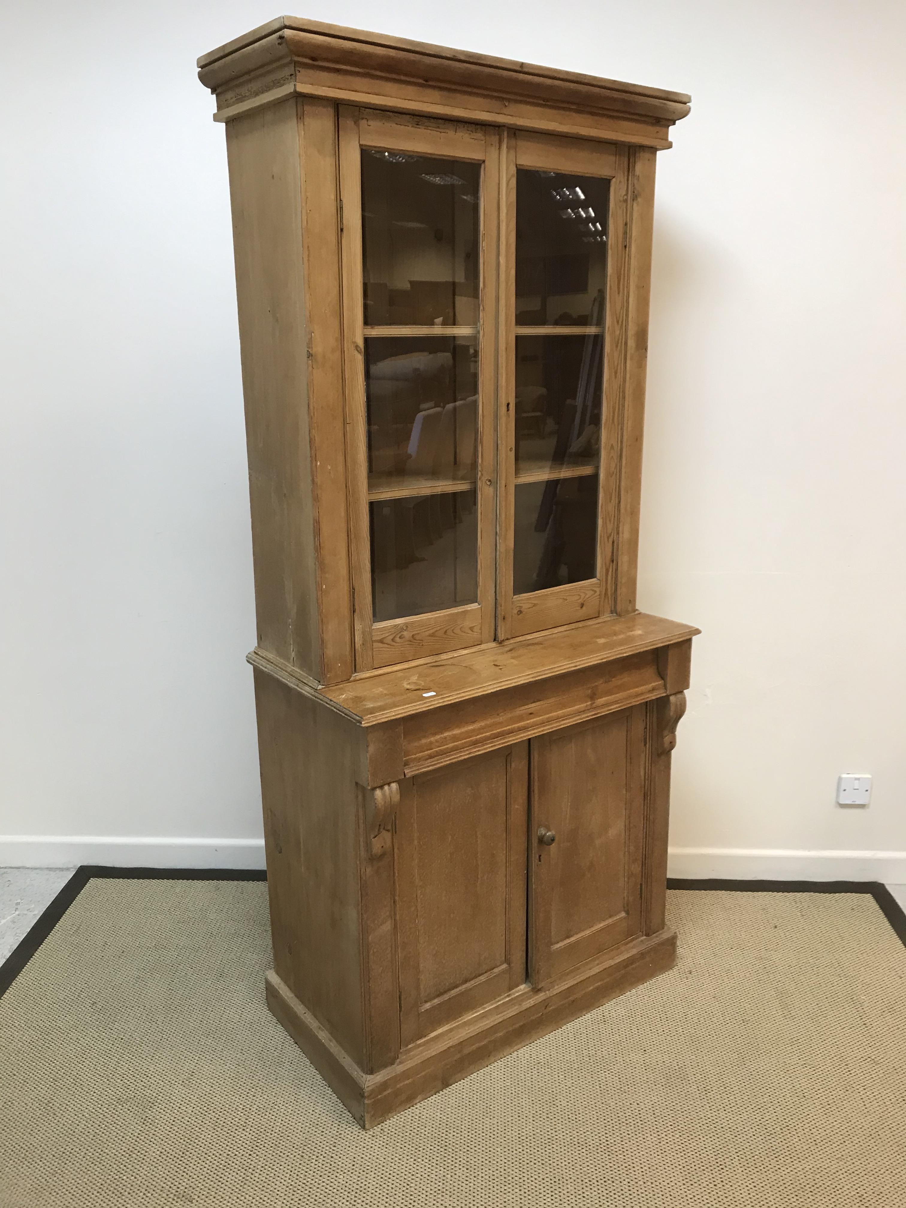 A Victorian pine bookcase cabinet with two glazed doors over a single drawer and two cupboard doors,
