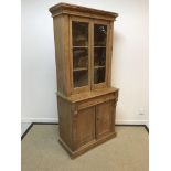 A Victorian pine bookcase cabinet with two glazed doors over a single drawer and two cupboard doors,