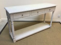 An OKA pale grey painted three drawer side table on turned supports united by an undertier, 150 cm