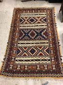 A Persian rug with striped geometric style decoration in blue, red, cream and orange, approx 200