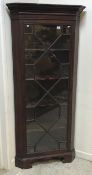 A mahogany freestanding corner cupboard in the George III style, the dentil and blind fretwork