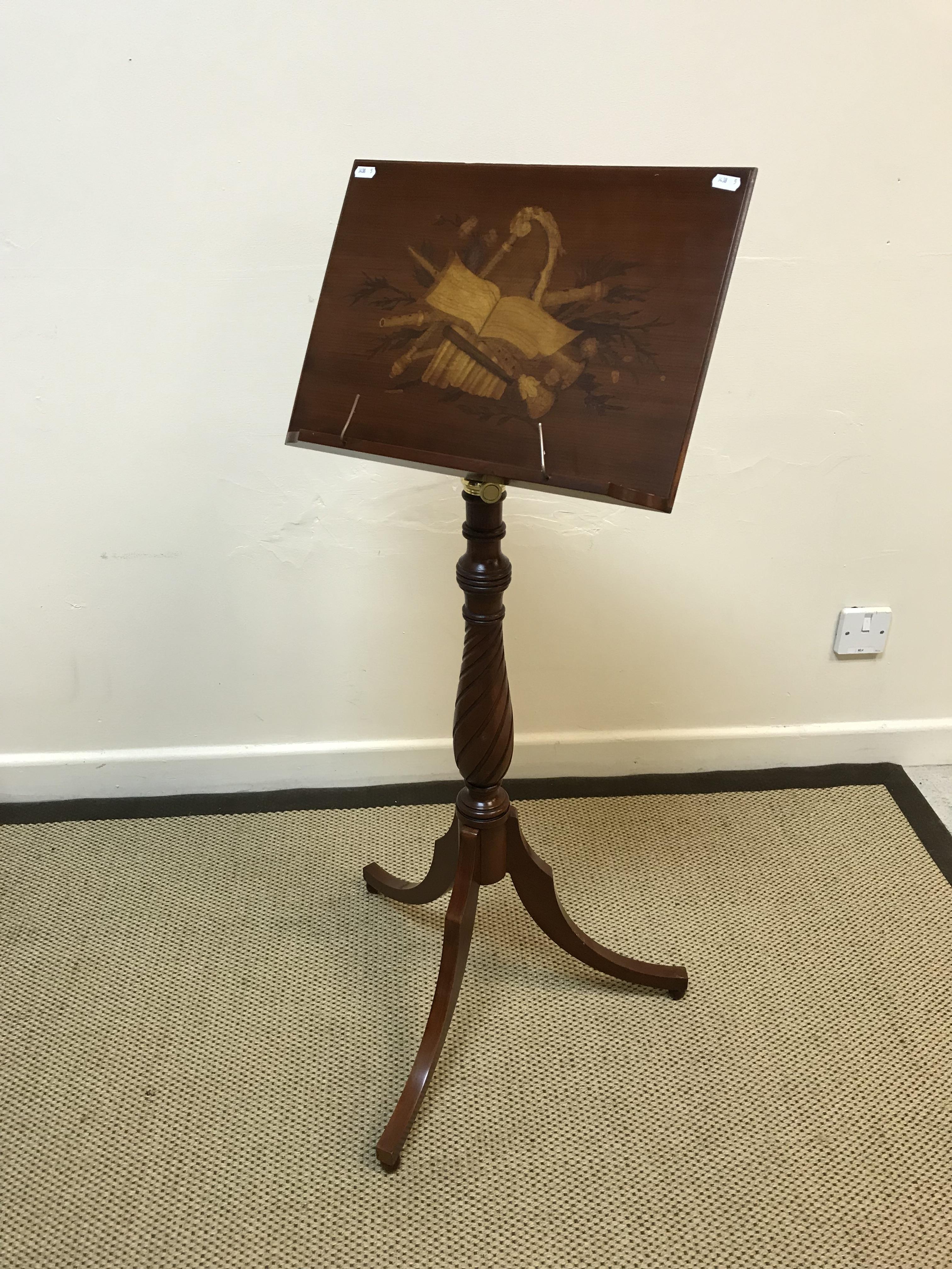 A modern mahogany and marquetry inlaid adjustable music stand, the main panel decorated with symbols