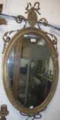 A circa 1900 giltwood and gesso oval wall mirror with scrolling foliate decoration (damaged), approx